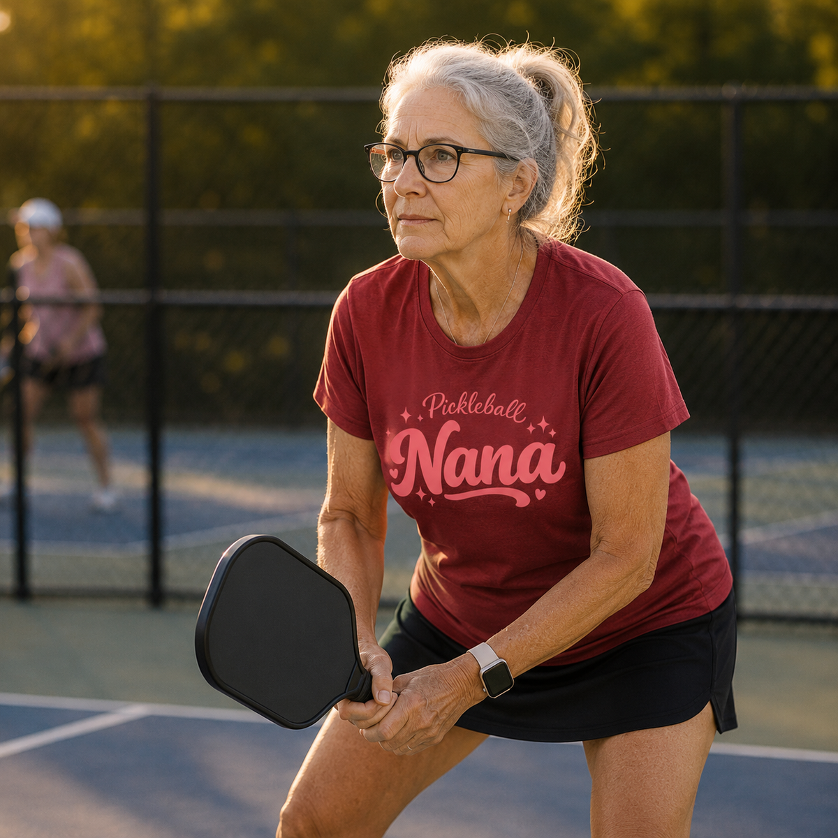 Grandma wearing Grandma Owns the Kitchen pickleball t-shirt in athletic stance on outdoor court