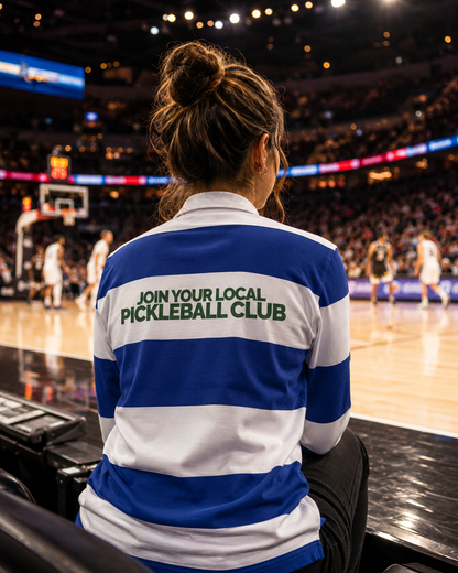 Woman wearing pickleball rugby polo courtside at basketball game