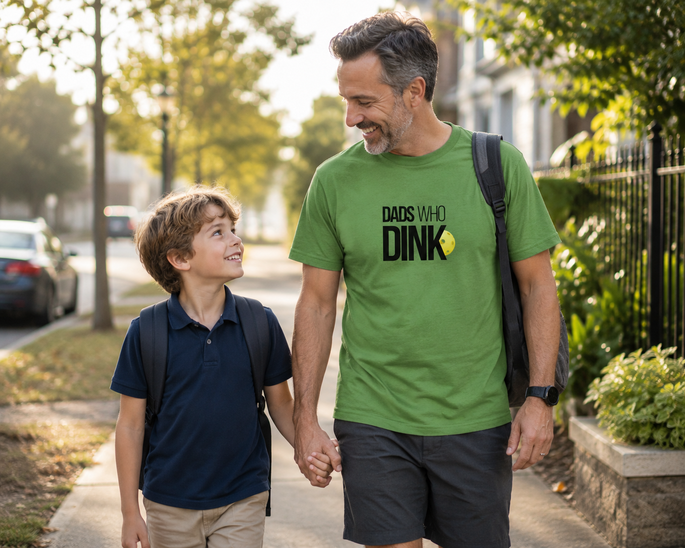 Dad wearing Dads Who Dink pickleball shirt walking with child to school