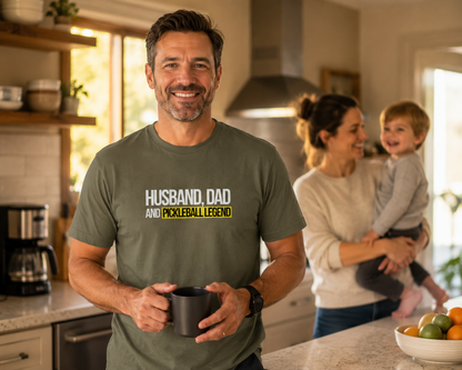Man wearing Husband Dad Pickleball Legend shirt in family kitchen with wife and child