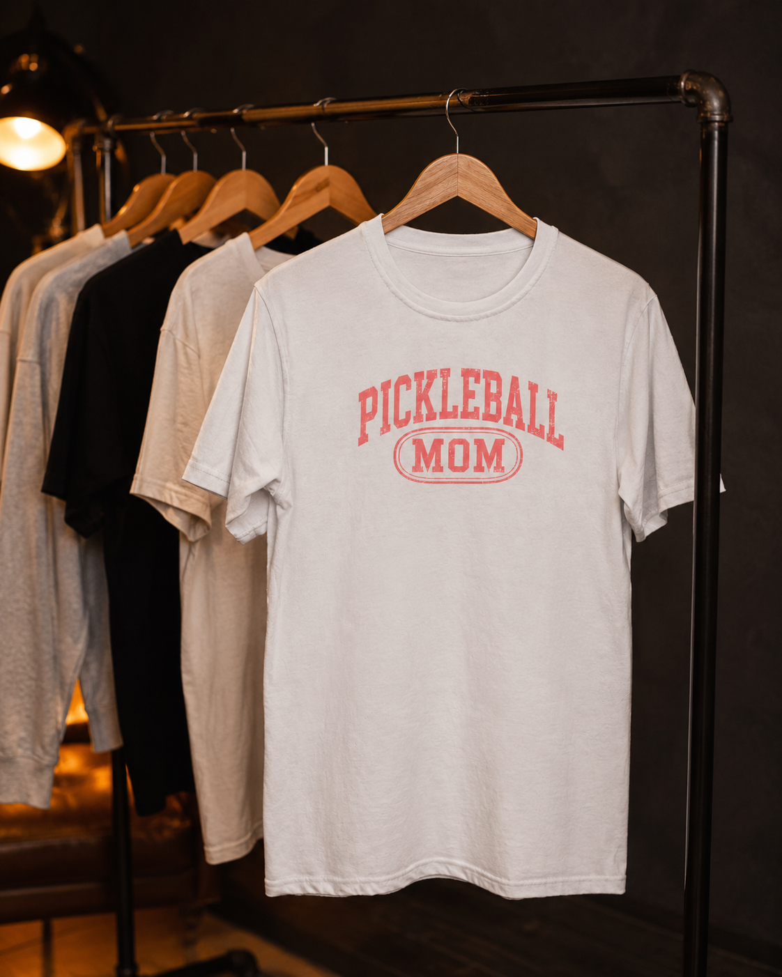 Pickleball Mom shirt on clothing rack in moody studio