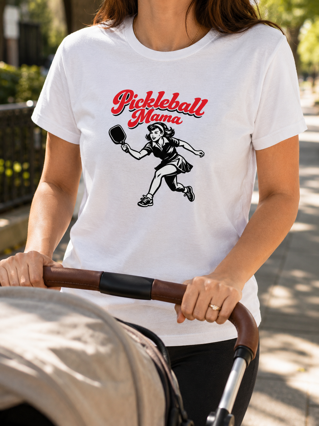 Woman wearing Pickleball Mama shirt pushing stroller close up front design visible